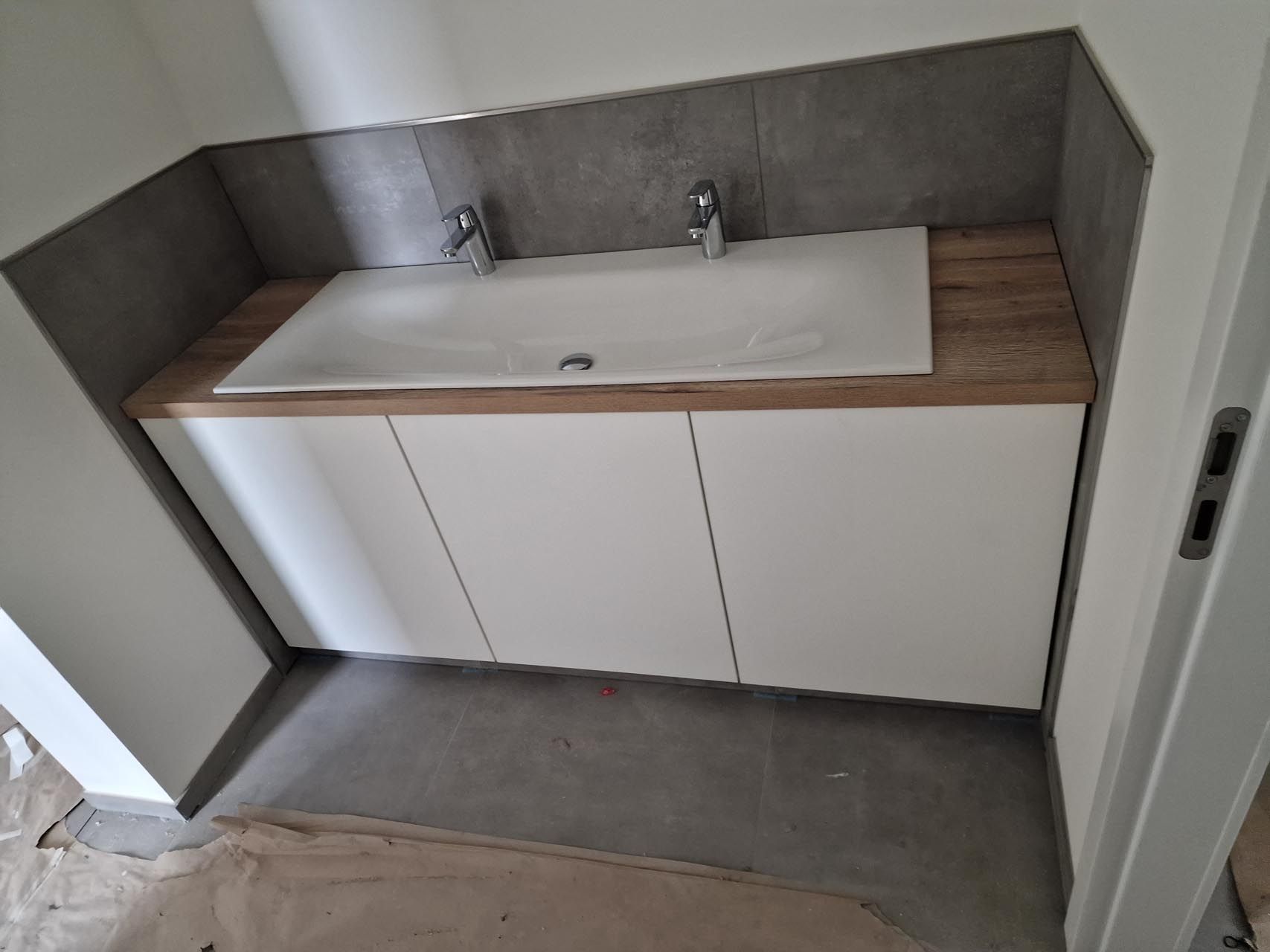 Ein Badezimmer mit zwei Waschbecken und einer Arbeitsplatte aus Holz von Hubert Uppenkamp GmbH