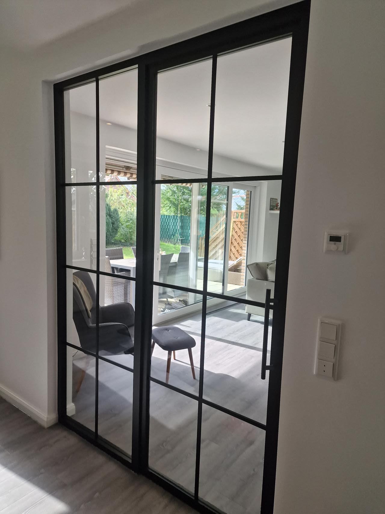 Ein Wohnzimmer mit einer Glasschiebetür von Hubert Uppenkamp GmbH