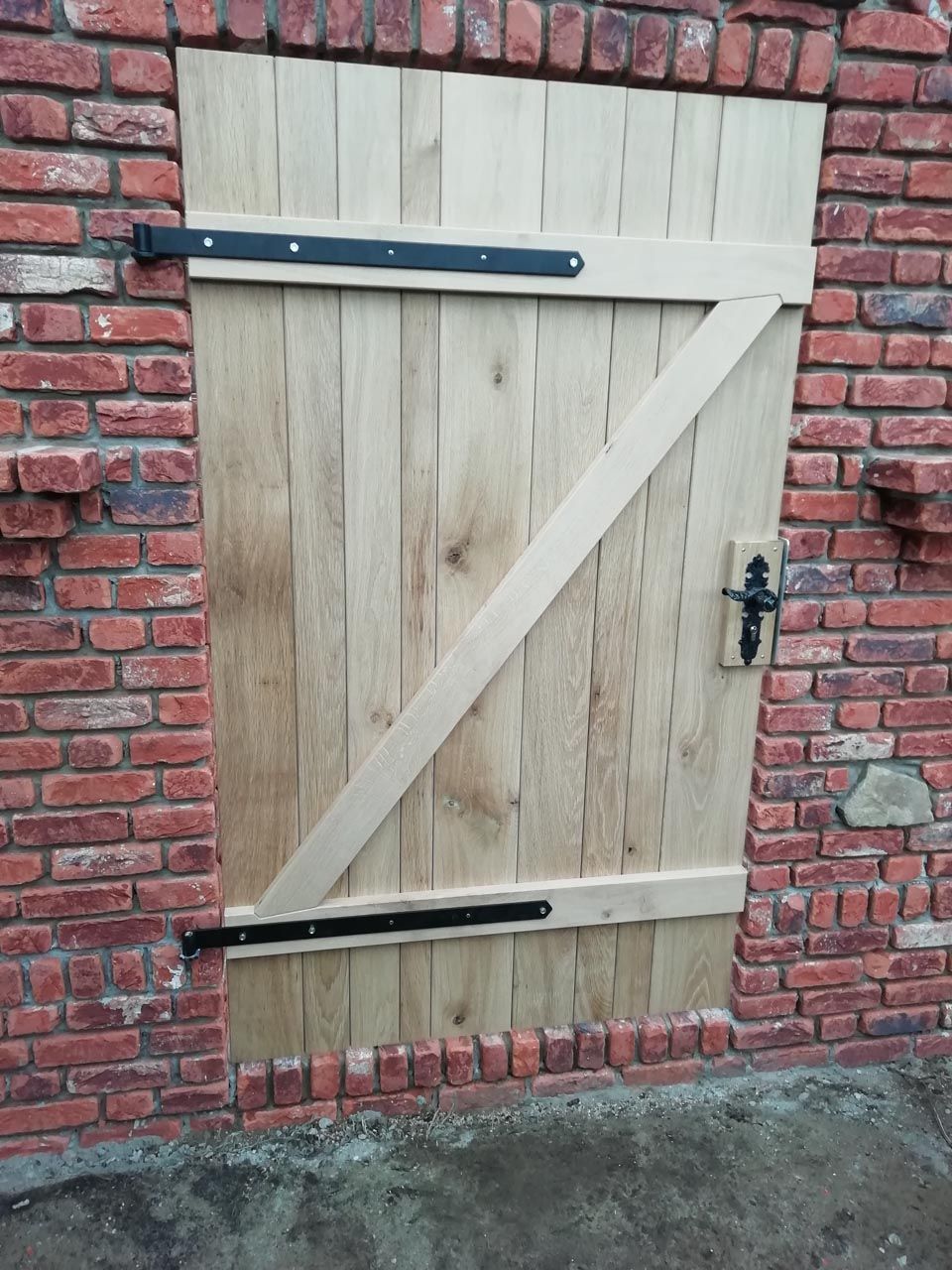 An einer Ziegelwand ist eine Holztür befestigt von Hubert Uppenkamp GmbH