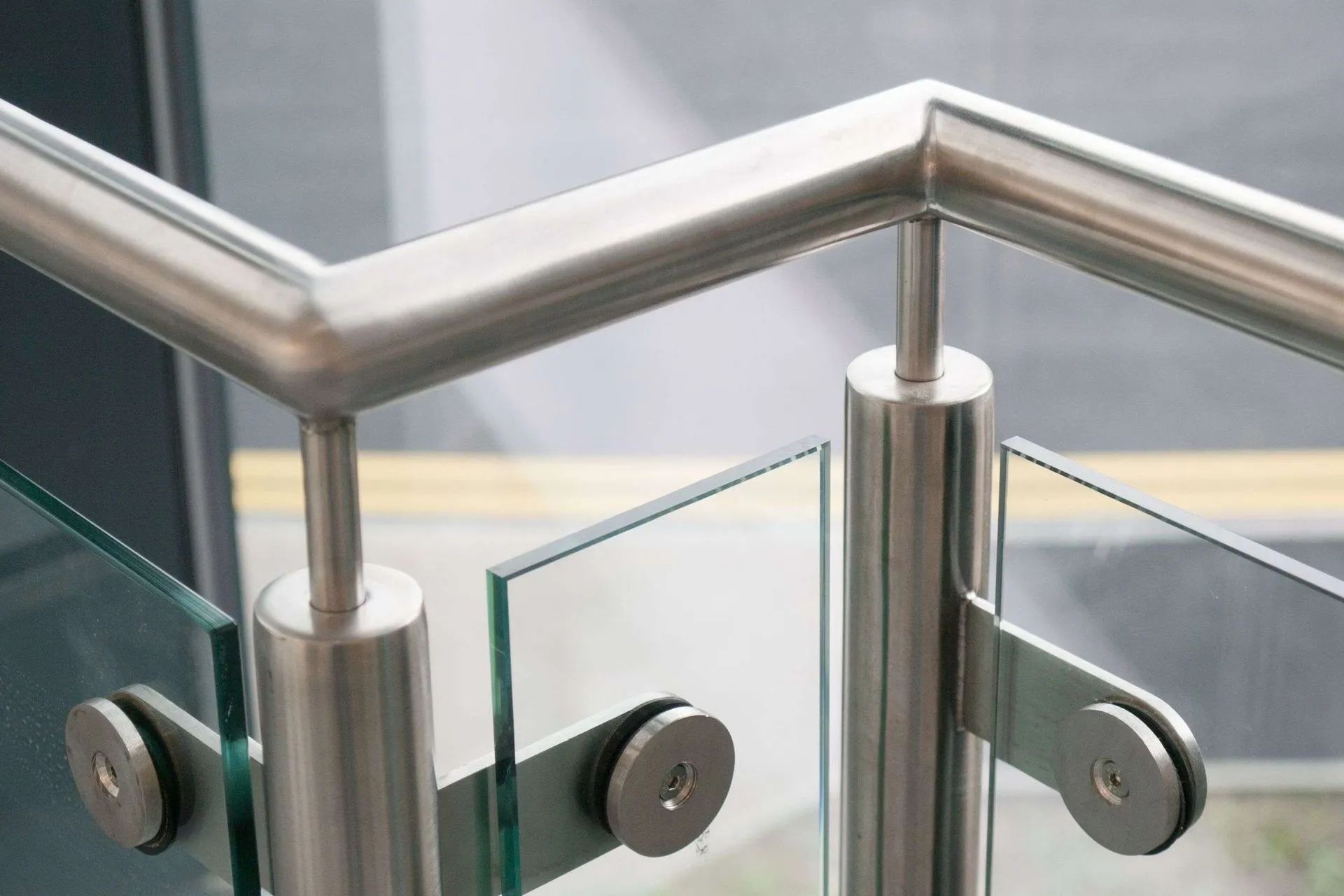 Barandilla de acero inoxidable con paneles de vidrio en una escalera o balcón moderno.