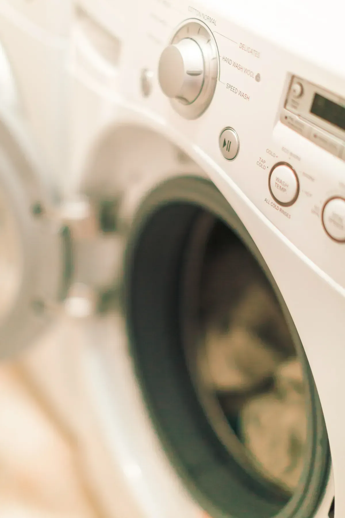 Lavadora blanca, puerta abierta, con panel de mandos visible.