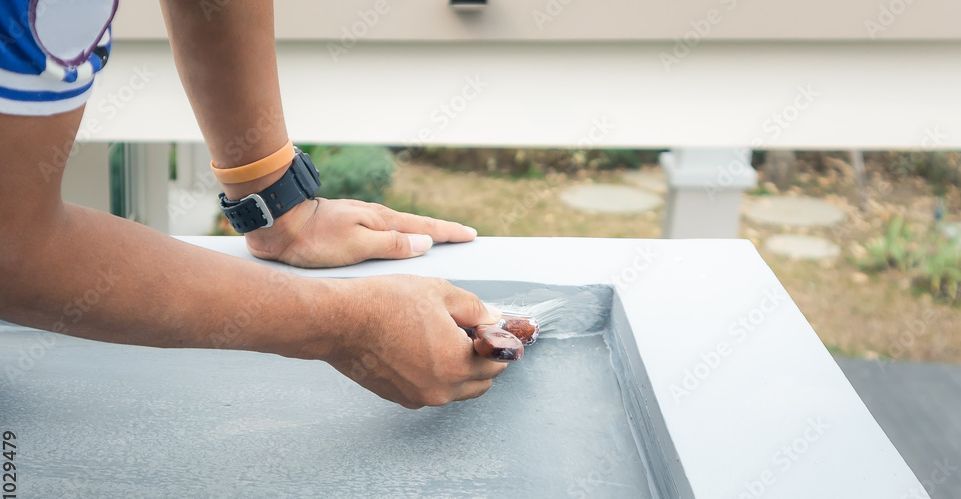 Mitarbeiter dichtet Dach ab