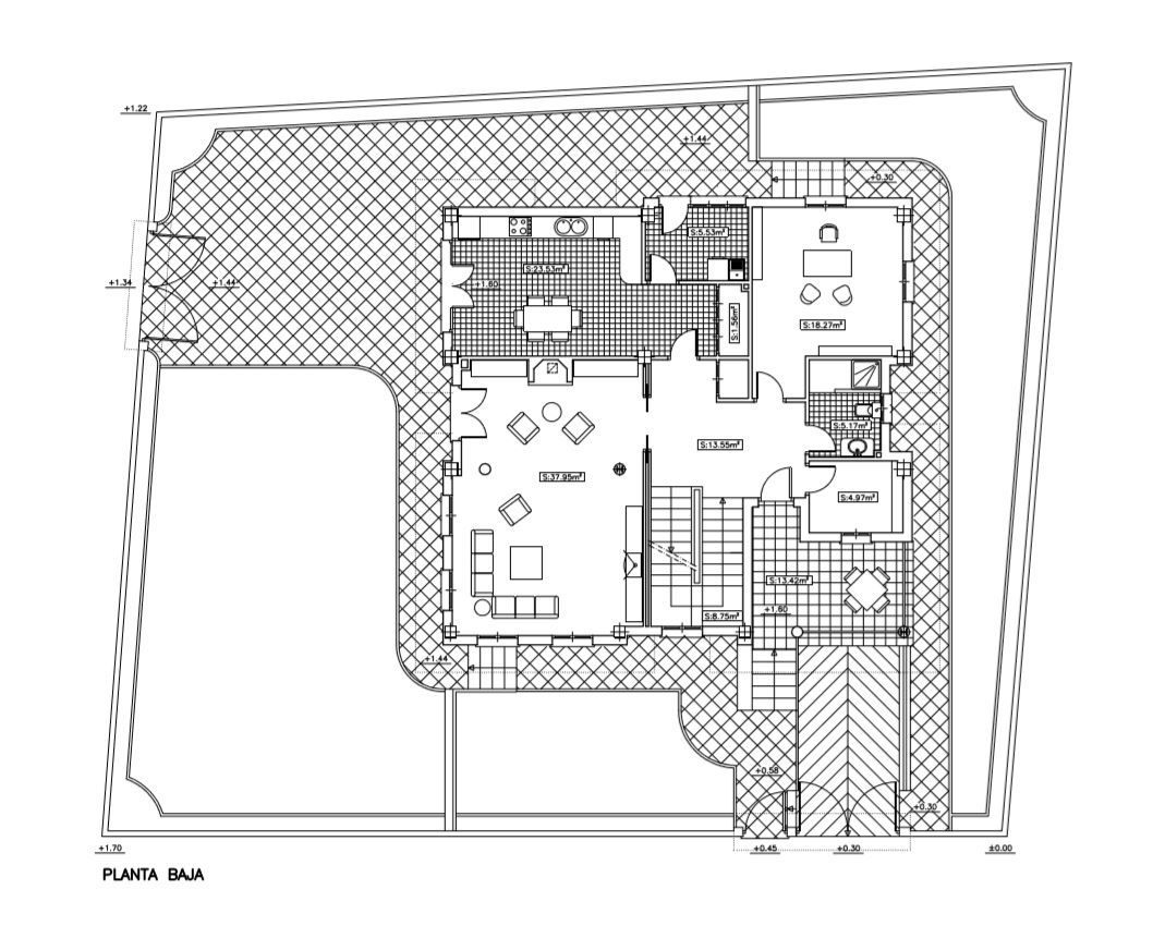Plano de una casa que muestra la distribución de las habitaciones, el mobiliario, las escaleras y las zonas pavimentadas circundantes.