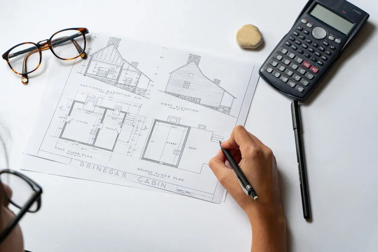 Persona usando un destornillador en la cerradura de una puerta. Hay un llavero con llaves en la cerradura.