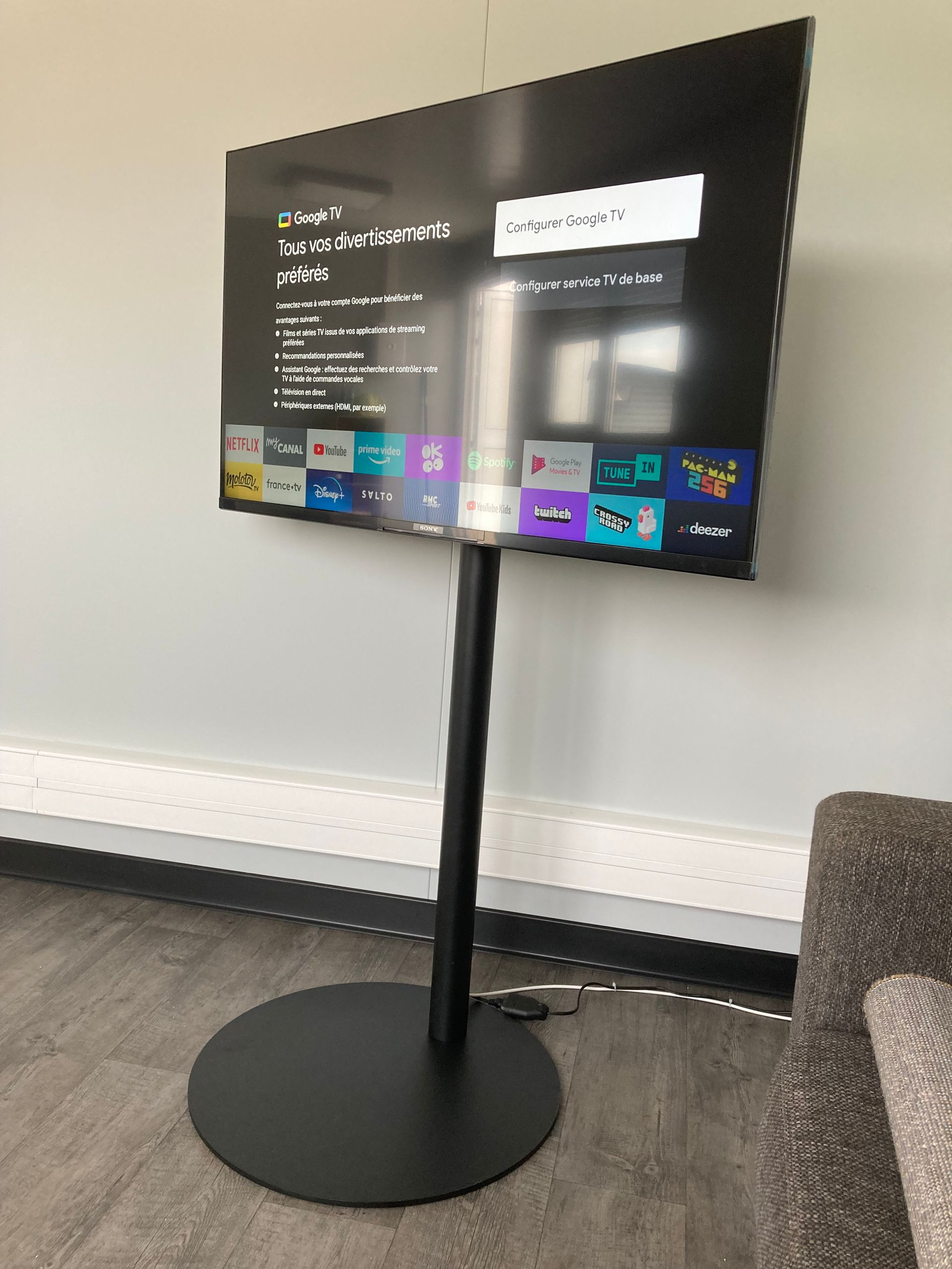 Télévision installée sur un pied avec socle rond et noir