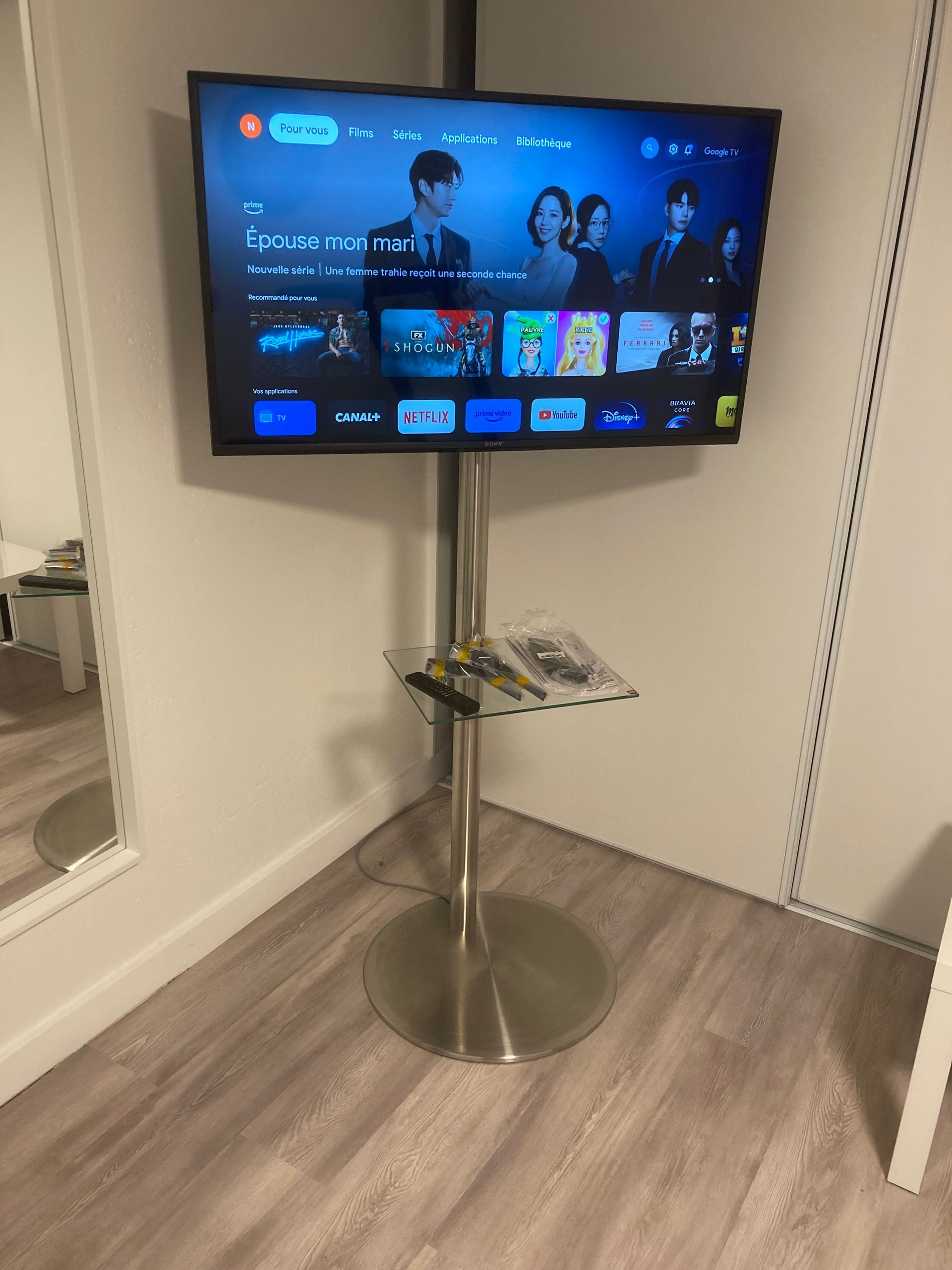 Télévision sur un pied en inox avec tablette