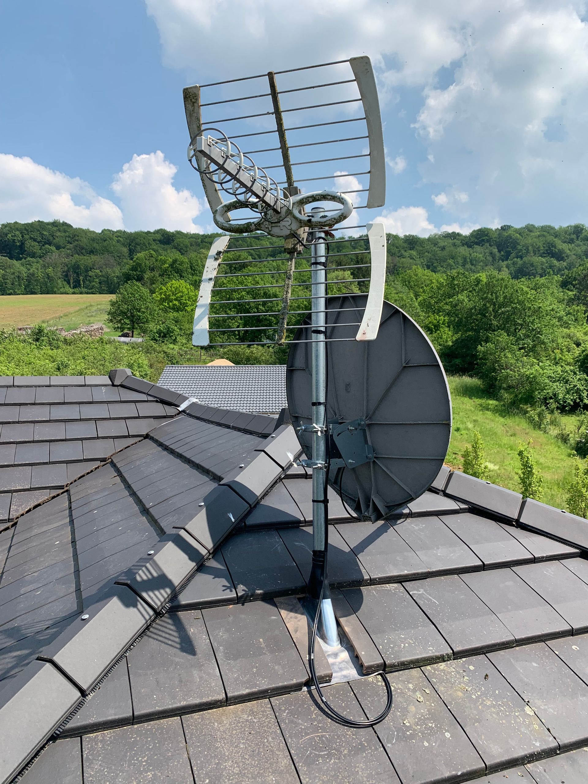 Antennes et parabole sur un toit en ardoise