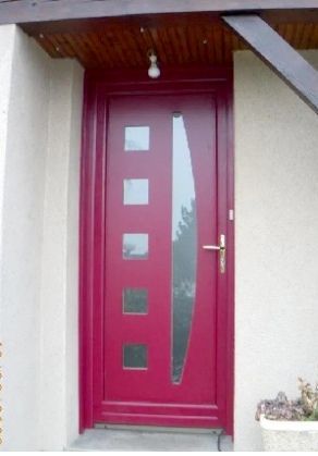 Porte d'entrée rouge avec fenêtres carrées et poignée dorée dans un hall d'entrée blanc