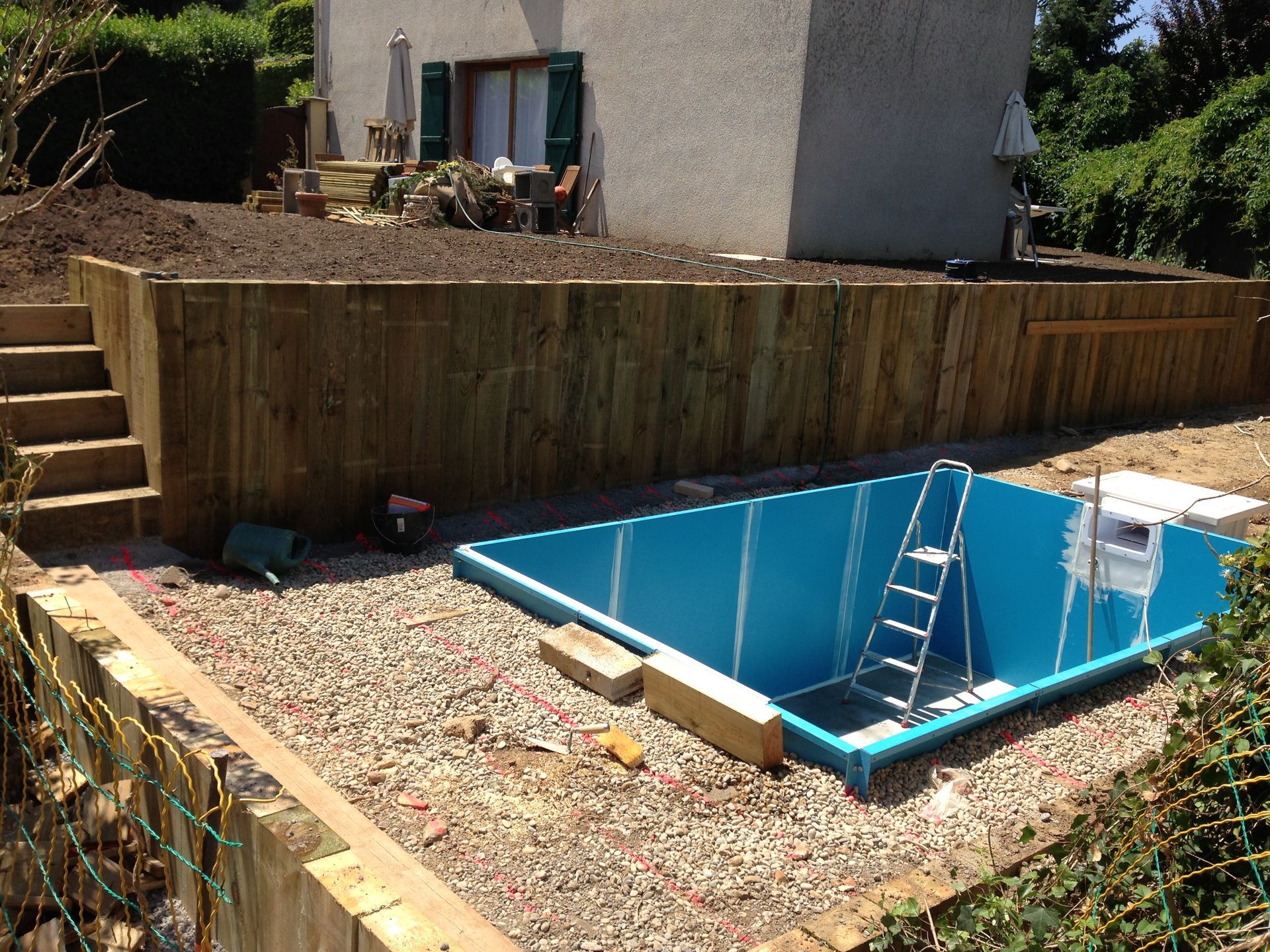 Piscine partiellement construite avec la préparation d'une construction de terrasse en bois.
