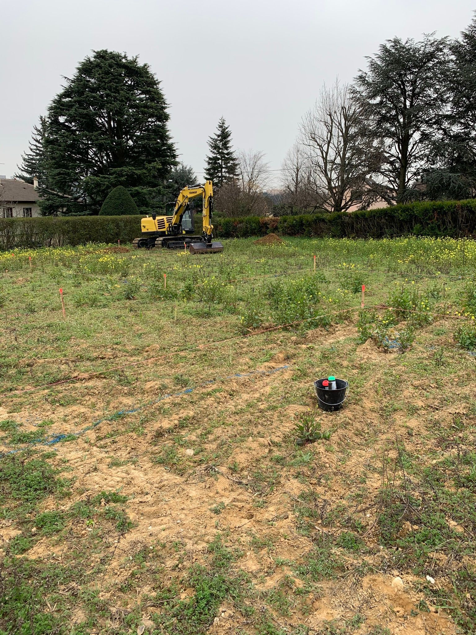 Un terrain, où se trouve une pelleteuse, délimité par des piquets.