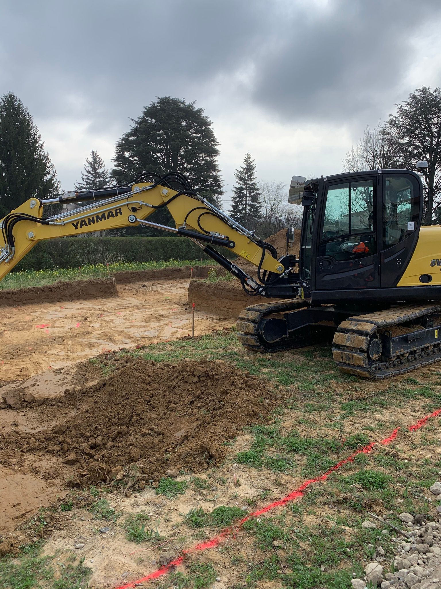 Une pelle mécanique creuse des fondations sur un terrain.