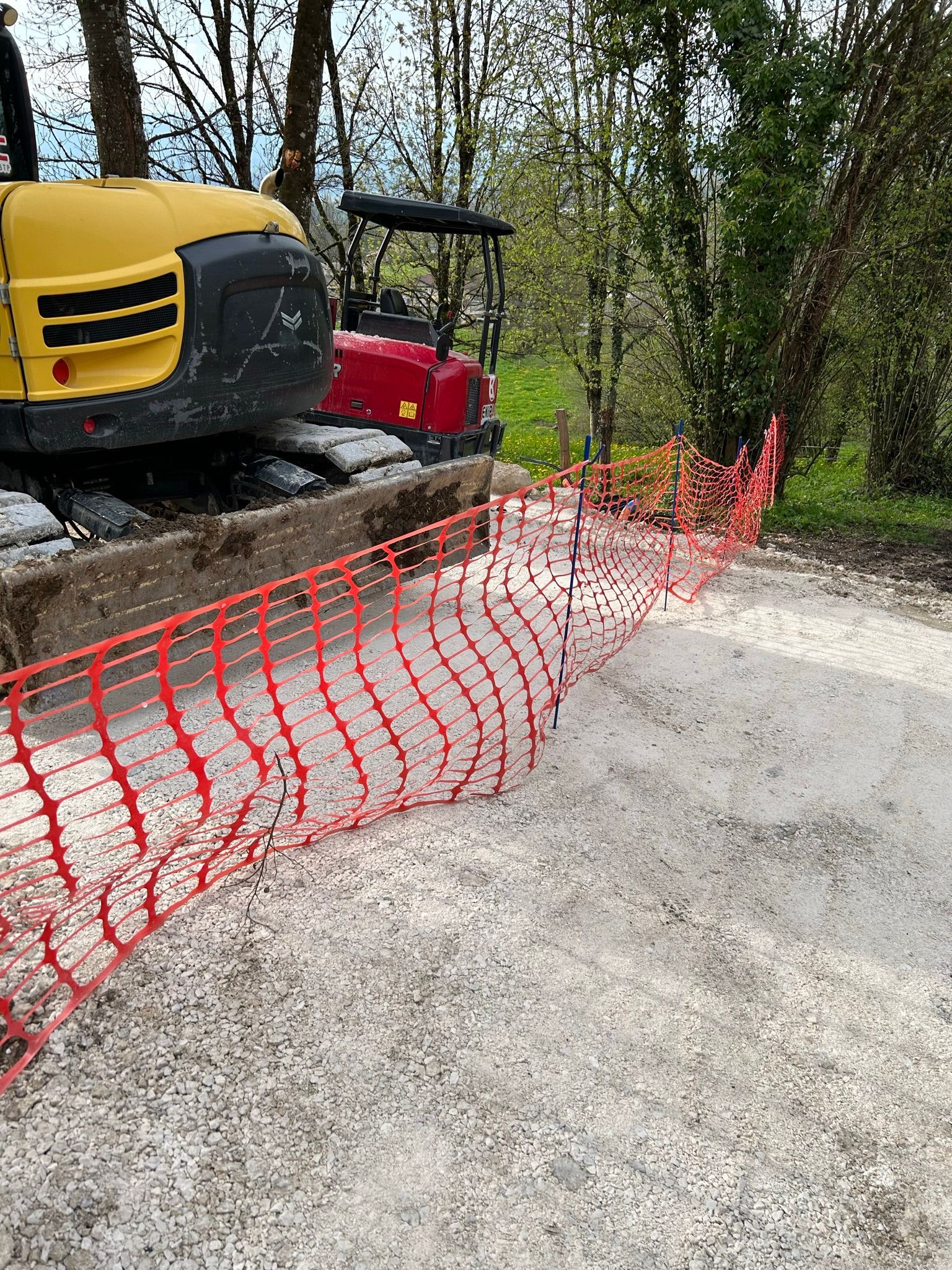 Des engins de chantier  délimités par un filet de sécurité.