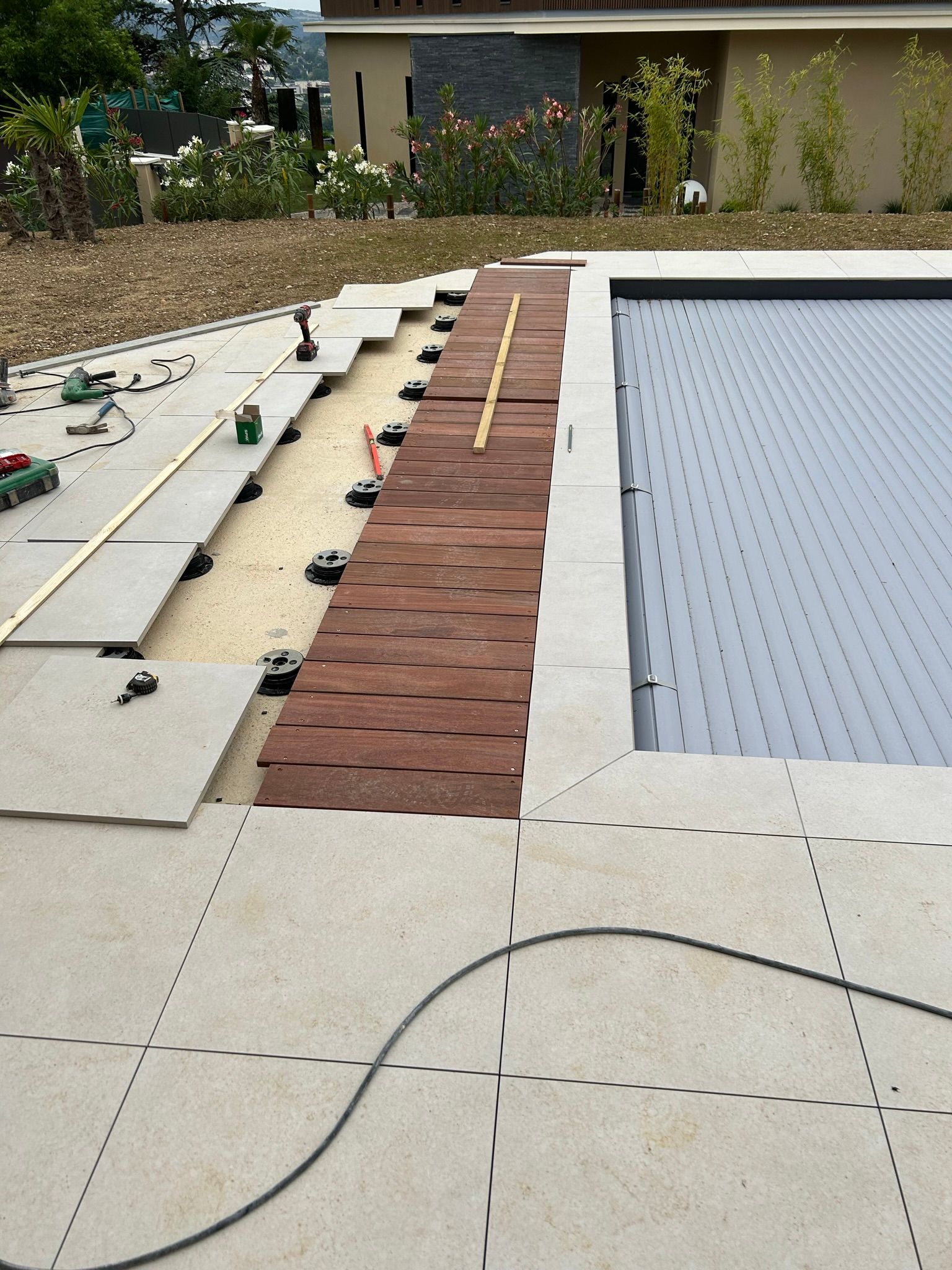 Une terrasse sur plot construite autour d'une piscine.