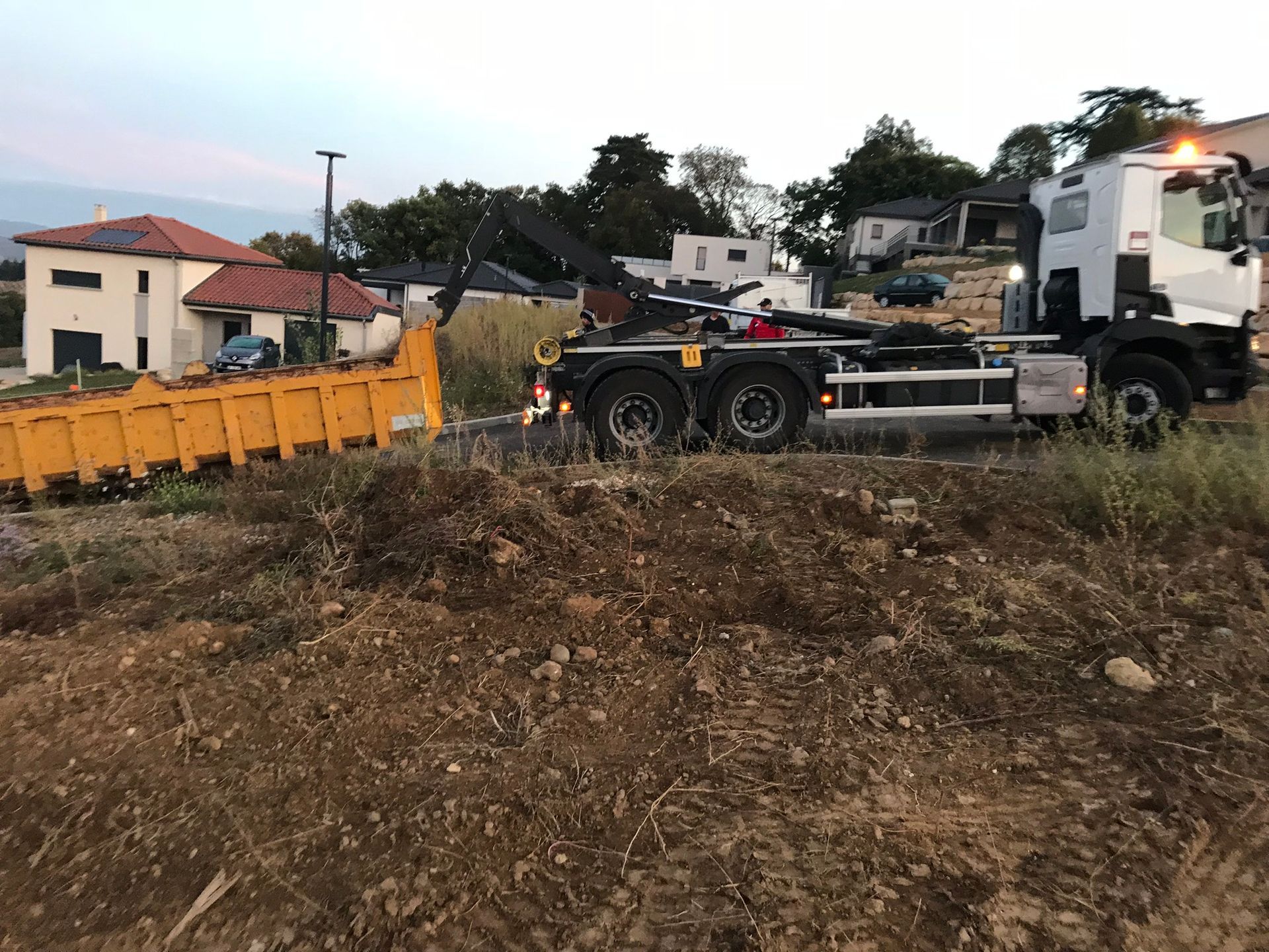 Un camion qui tracte une remorque près d'un terrain en friche.