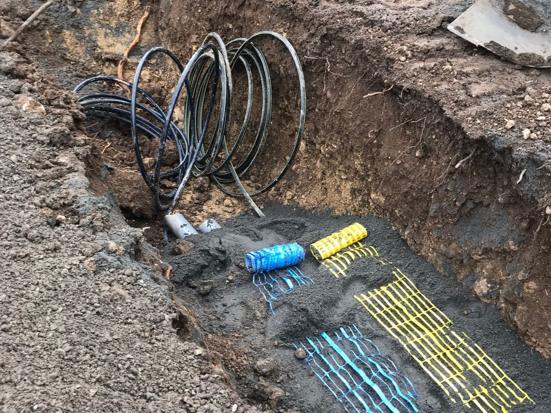 Gros plan sur des gaines dans une tranchée.