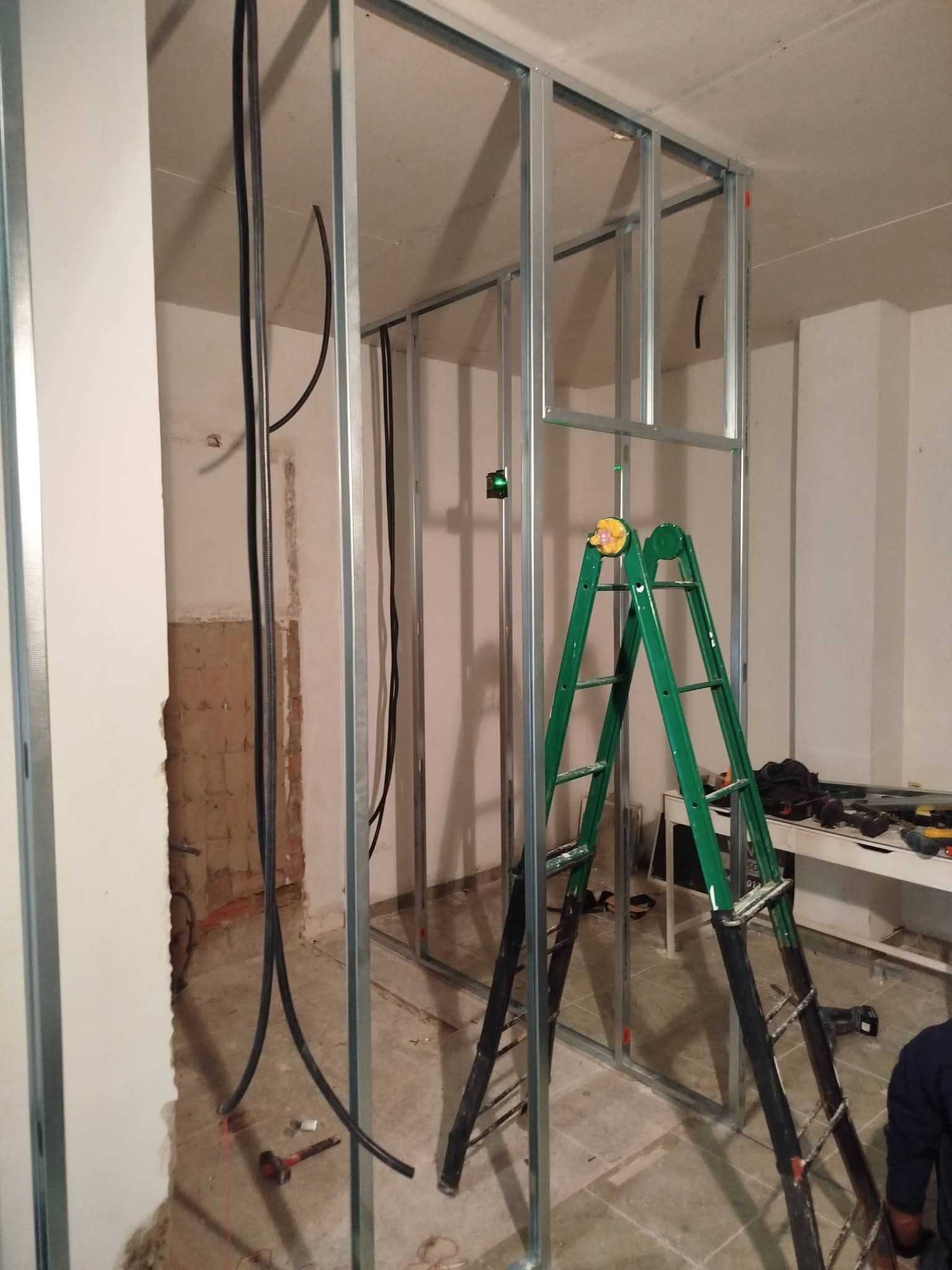 Una escalera verde con forma de A se encuentra dentro de una habitación