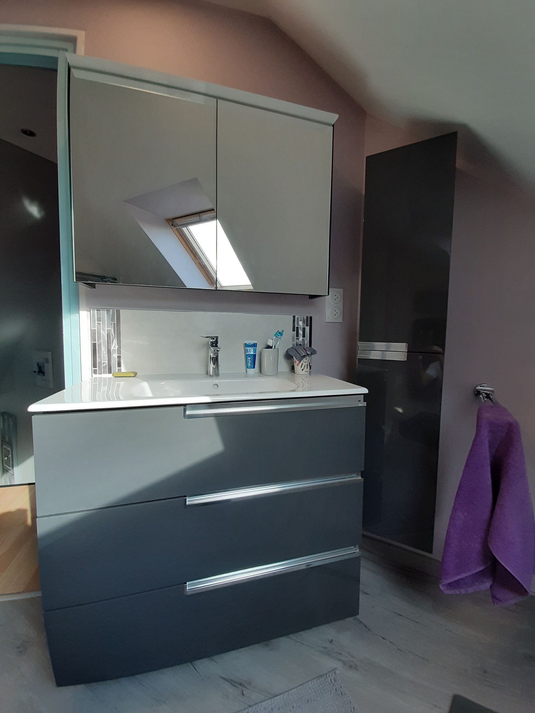 Salle de bain avec miroir, placard et porte-serviettes.