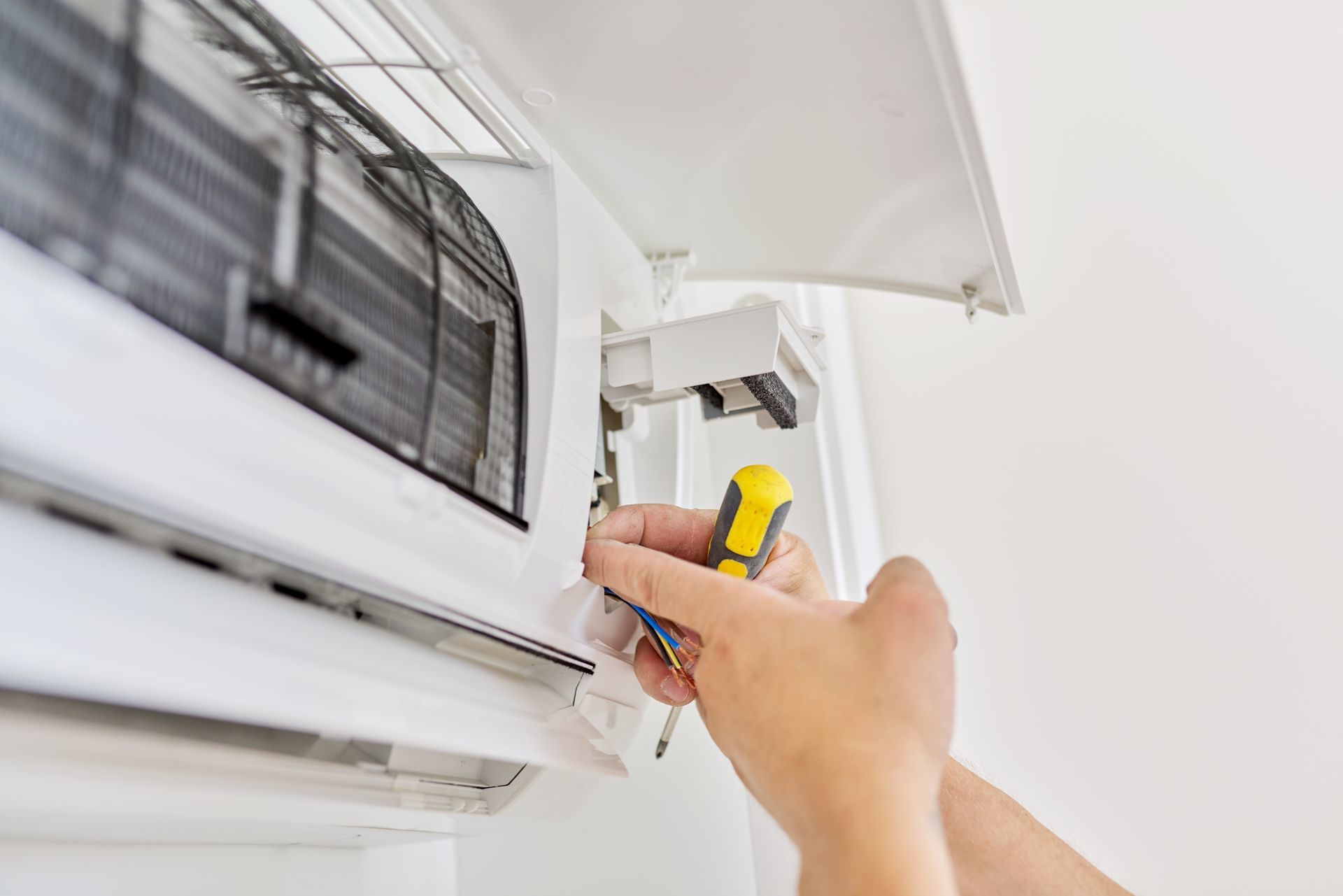 Un technicien répare une climatisation.