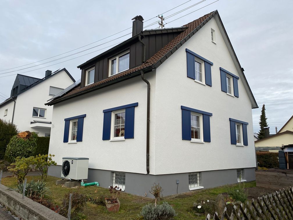 Ein weißes Haus mit blauen Fensterläden