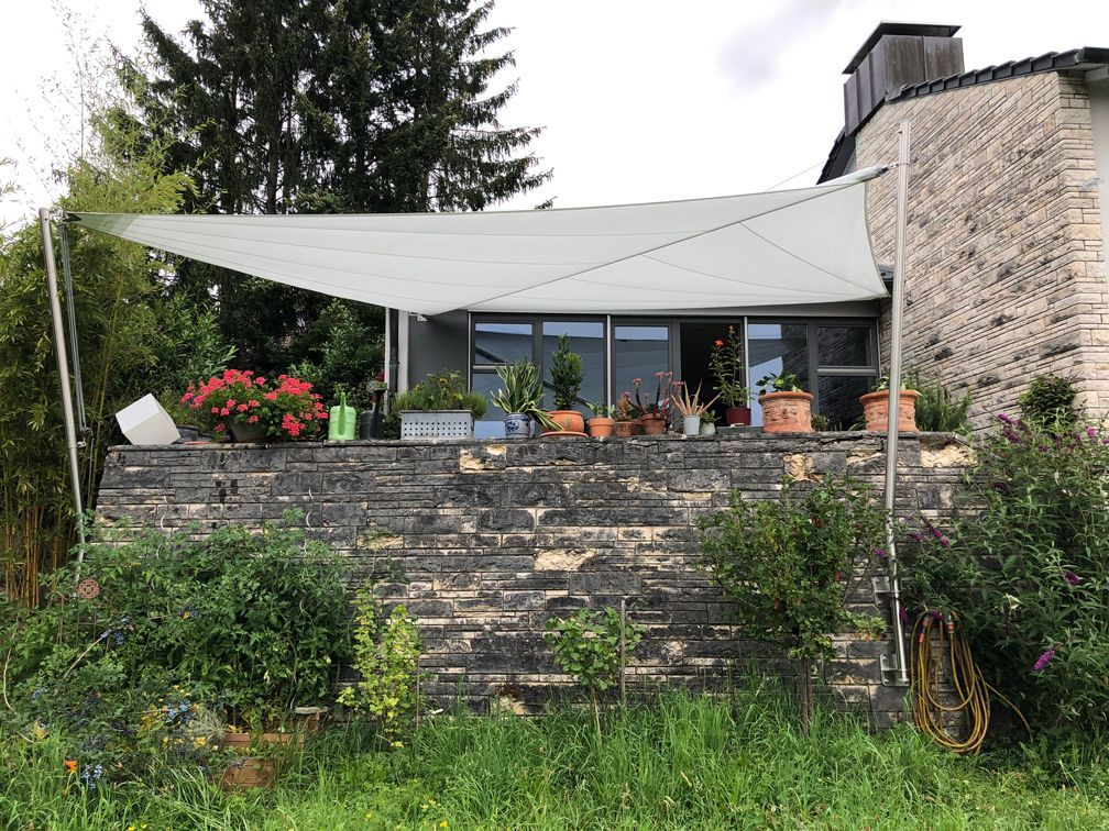 Ein Haus mit einer weißen Markise an der Seite.