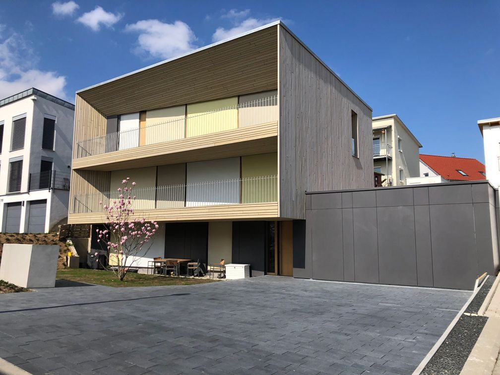 Ein großes Haus mit vielen Fenstern und einer Auffahrt davor