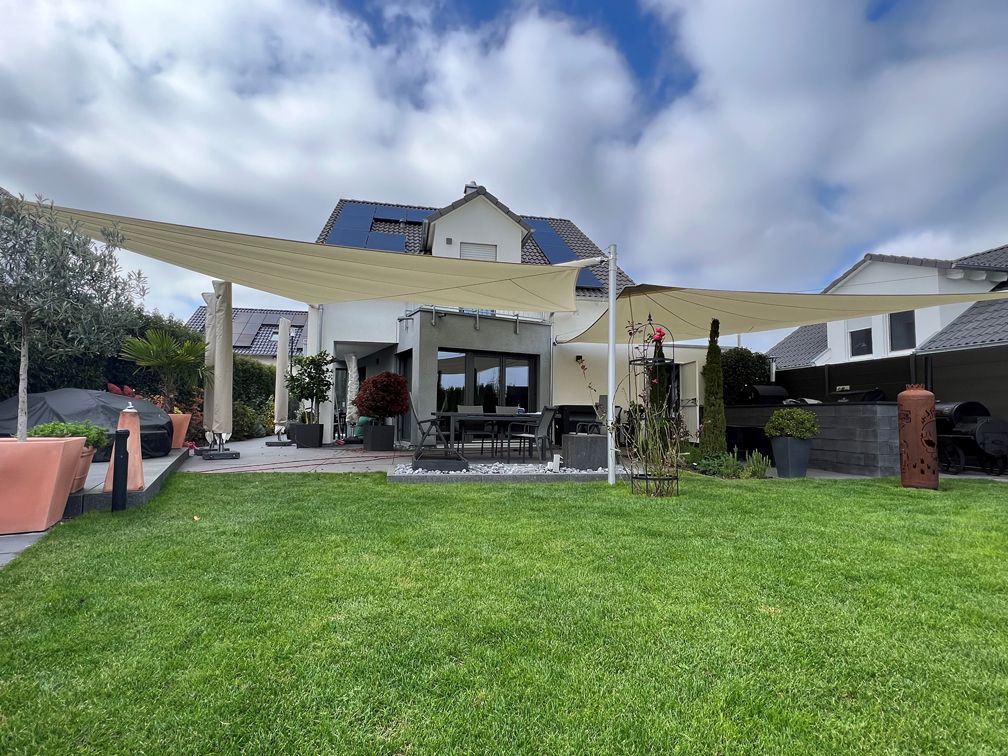 Ein großes Haus mit einer großen Wiese davor.