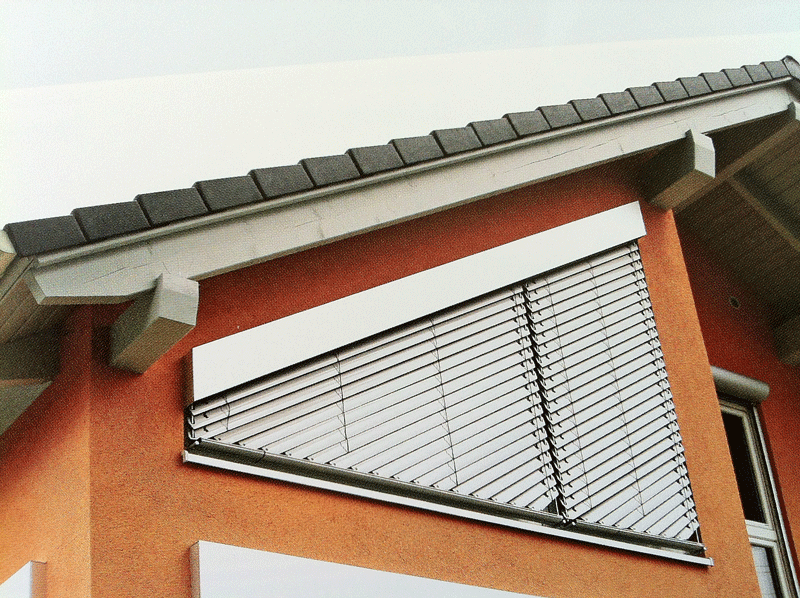 Ein Gebäude mit einem Dach und einem Fenster mit Jalousien