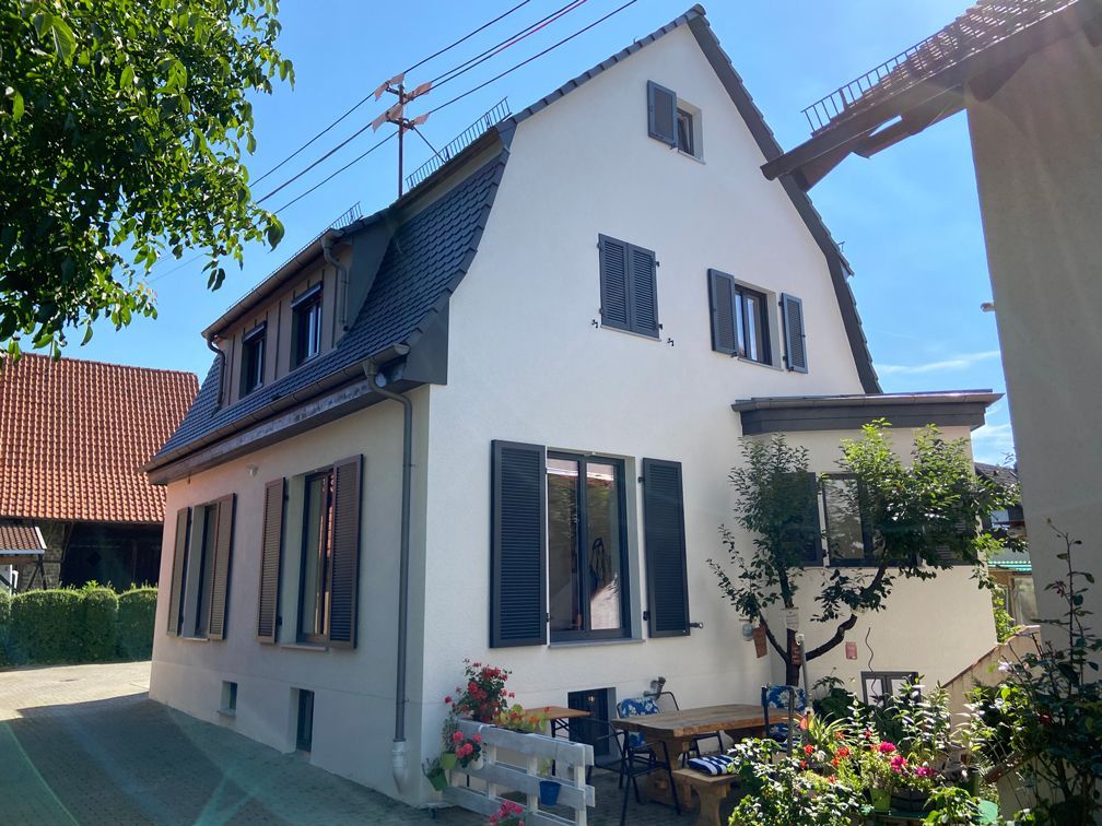 Ein weißes Haus mit schwarzen Fensterläden