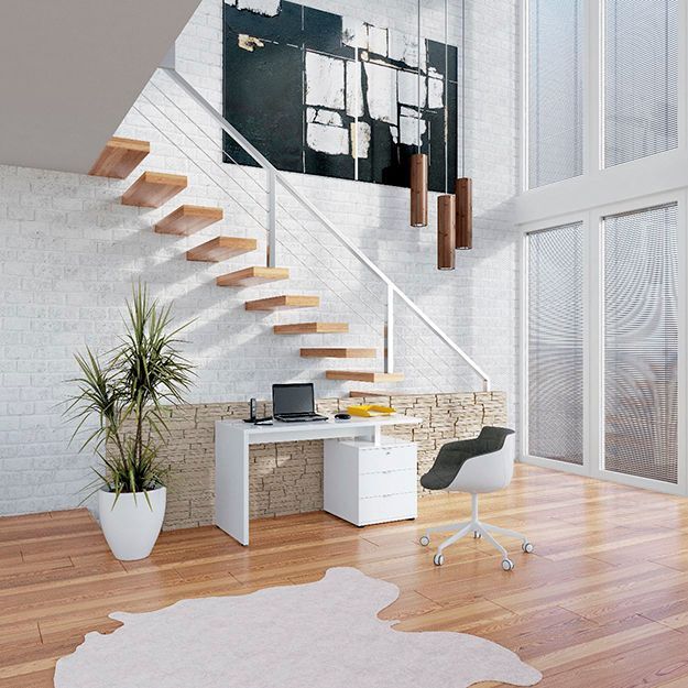 Ein Raum mit einer Treppe und einem Schreibtisch mit einem Laptop darauf