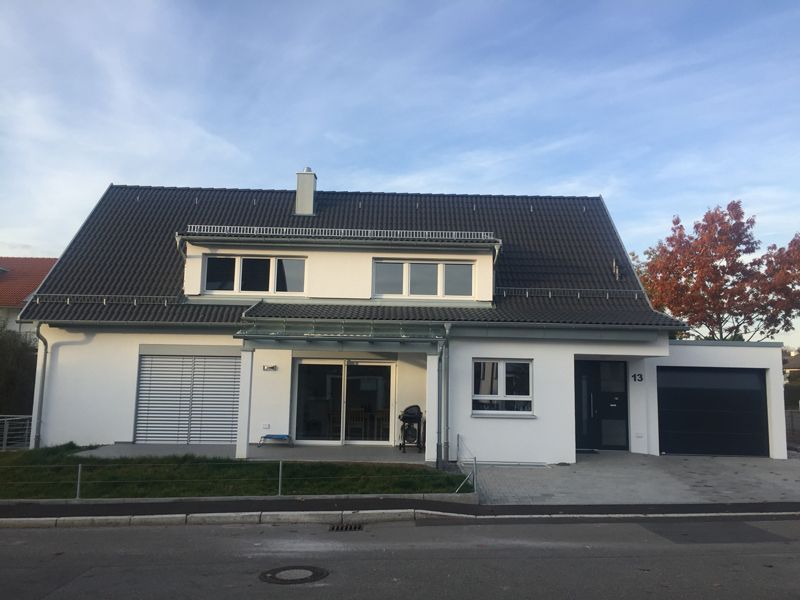 Ein großes weißes Haus mit einem schwarzen Dach