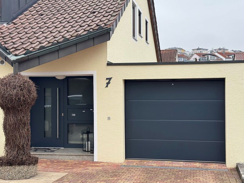 Ein Haus mit einem Garagentor und einer Tür mit der Nummer 7 darauf.