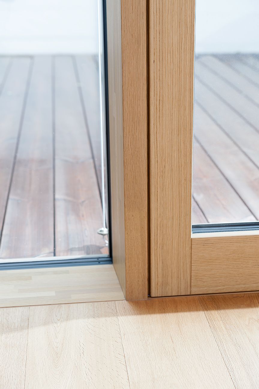 Eine Nahaufnahme einer Holztür mit einem Holzdeck im Hintergrund.