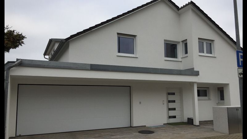 Ein weißes Haus mit einem weißen Garagentor