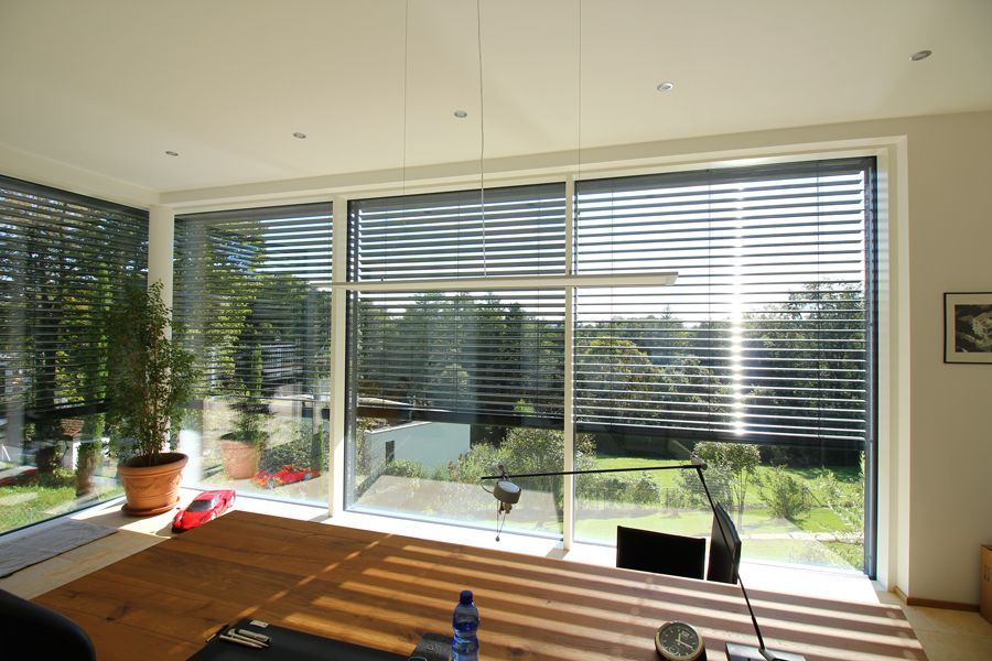 Ein Wohnzimmer mit vielen Fenstern und Holzboden