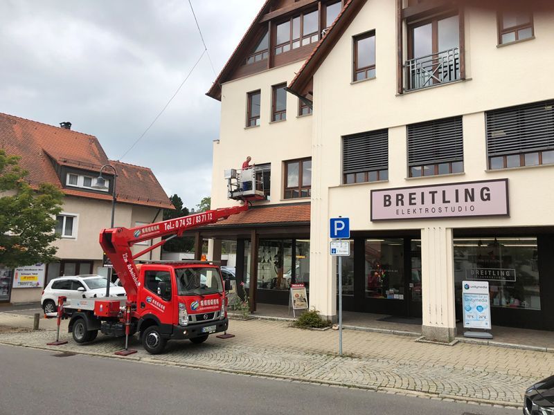 Vor einem Breitling-Geschäft parkt ein roter Lastwagen.