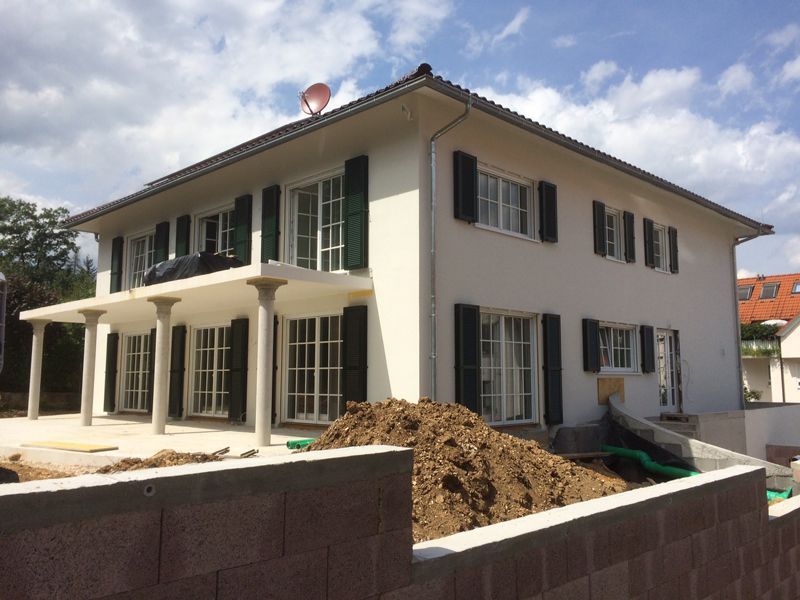 Ein weißes Haus mit schwarzen Fensterläden entsteht