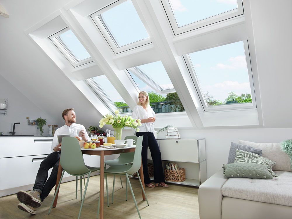 Ein Mann und eine Frau sitzen an einem Tisch in einem Wohnzimmer.