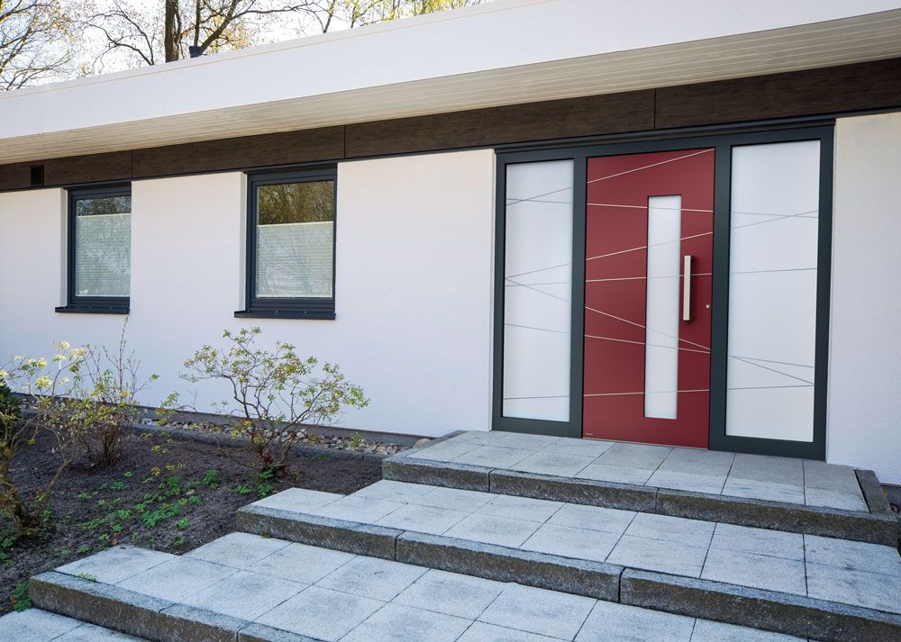 Ein weißes Haus mit einer roten Tür und Treppe