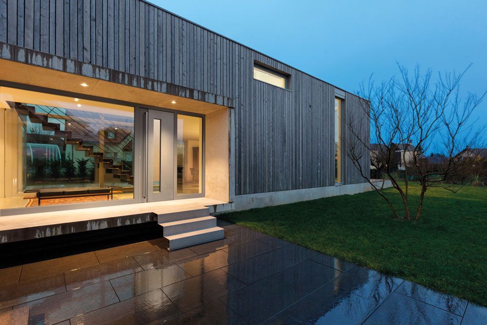 Ein modernes Holzhaus mit großem Fenster und Treppe.