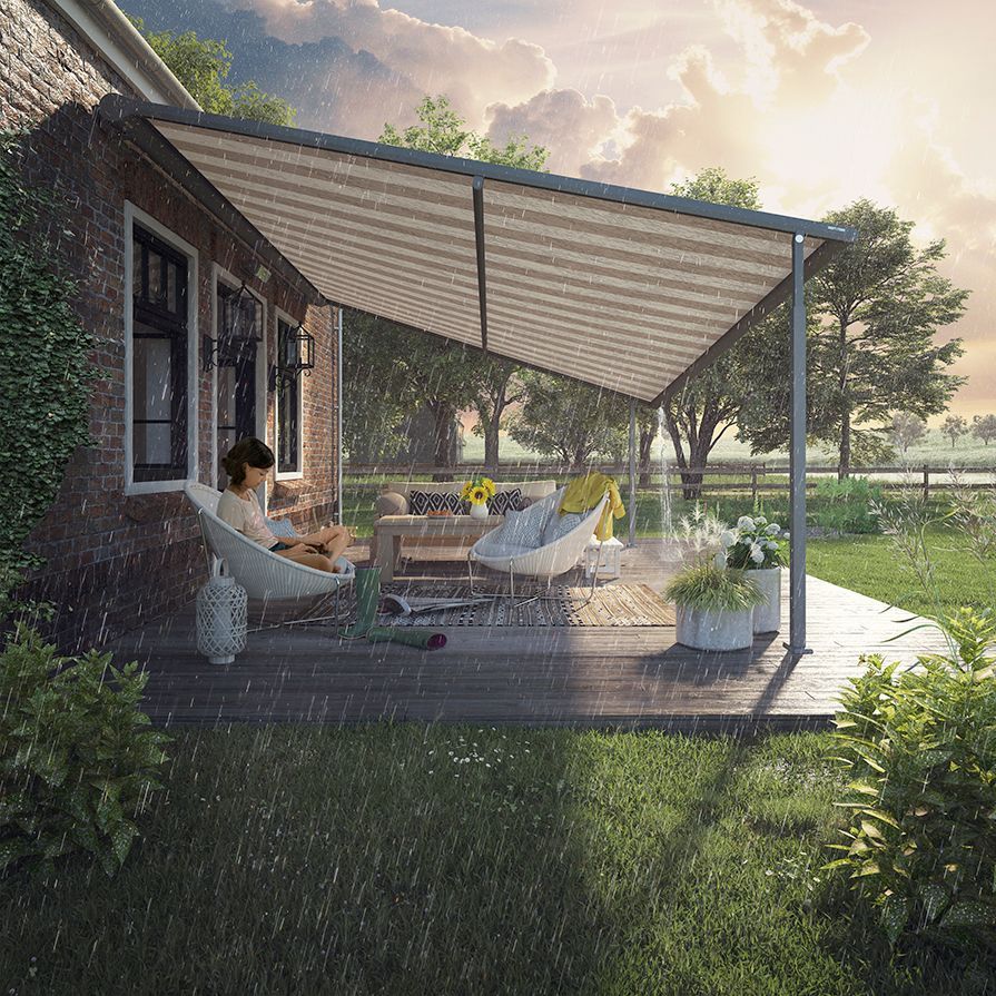 Ein Mann sitzt im Regen unter einem Baldachin auf einer Terrasse.