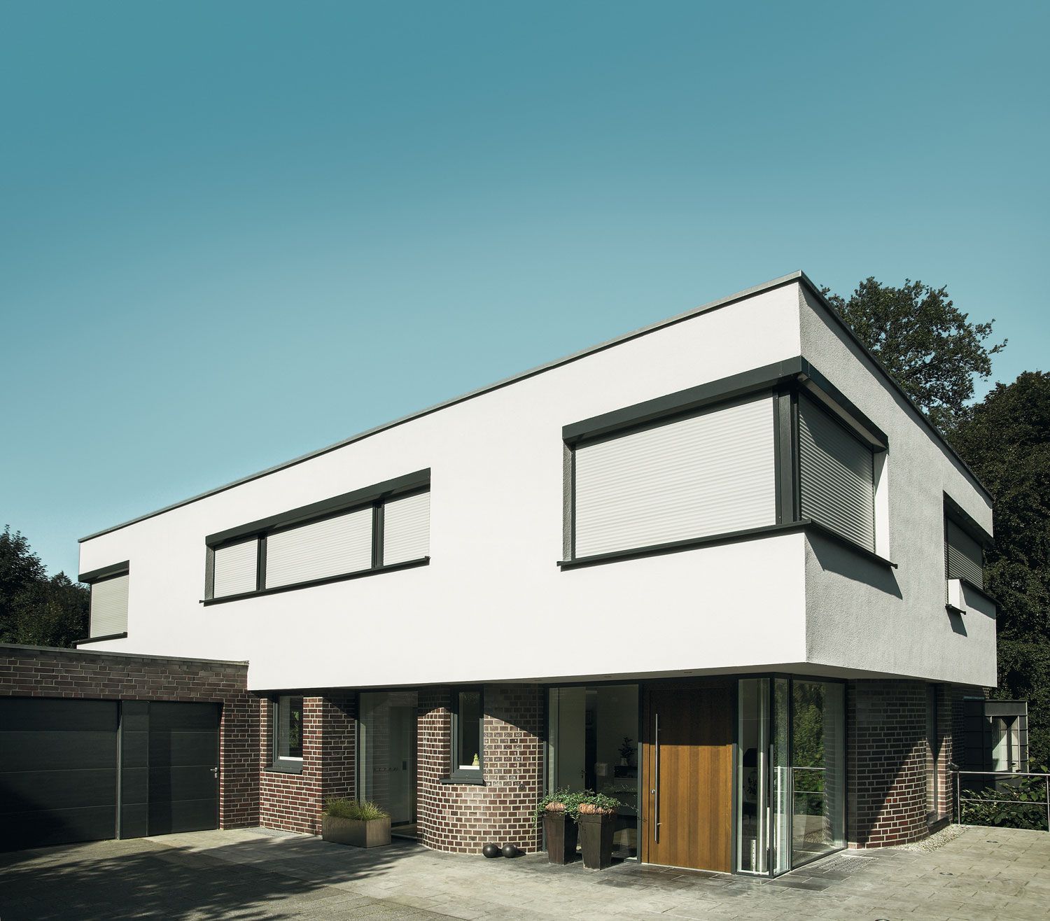 Ein weißes Haus mit einer Holztür und Fenstern