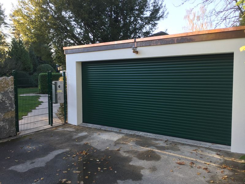 Ein grünes Garagentor mit einem Kupferdach