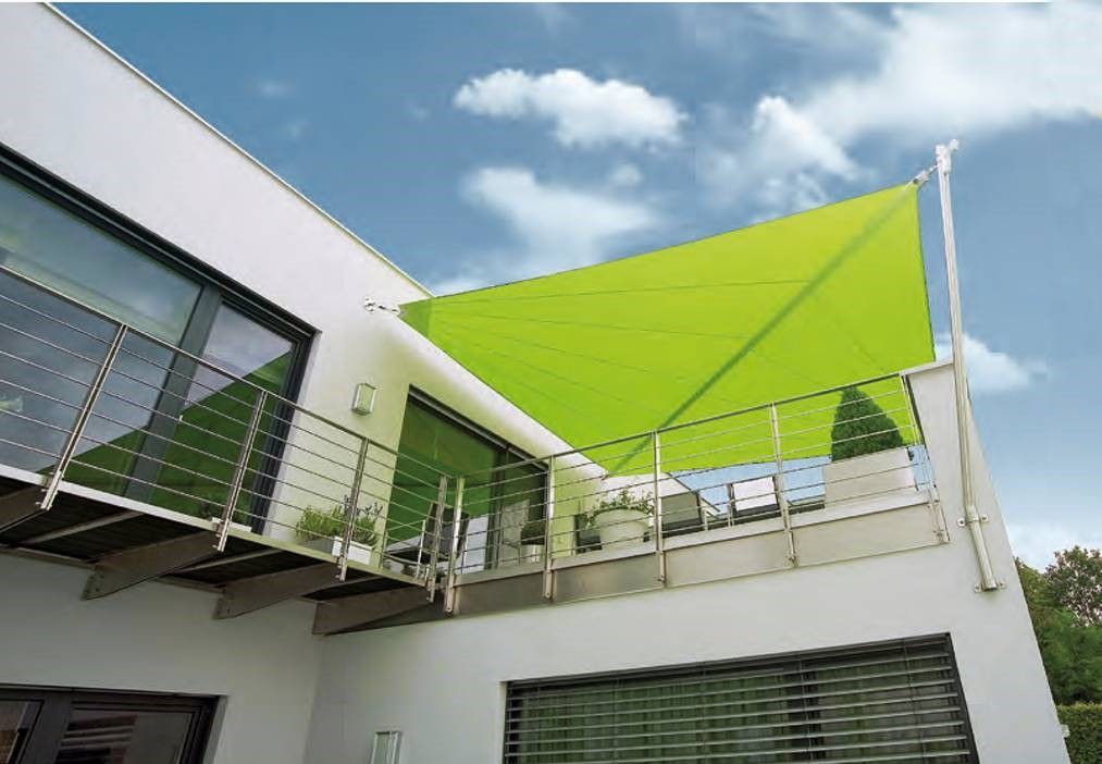 Ein weißes Haus mit einer grünen Markise auf dem Dach