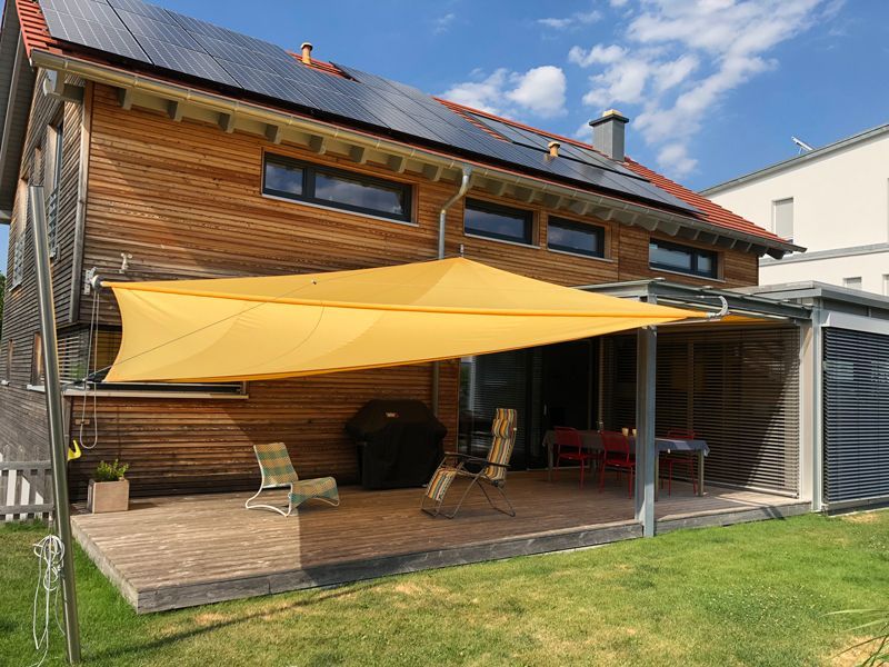 Ein Haus mit einem gelben Regenschirm davor.