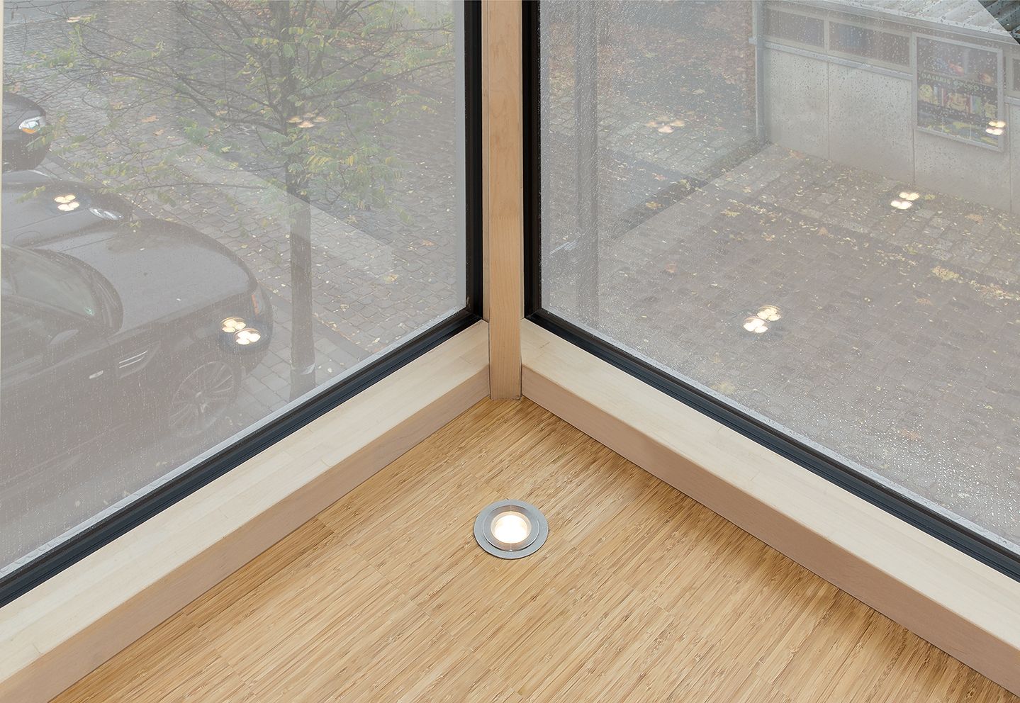 Eine Zimmerecke mit einem Fenster und einer Lampe auf dem Boden