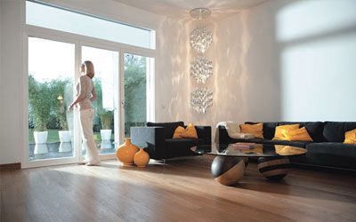 Eine Frau steht in einem Wohnzimmer und schaut aus dem Fenster.