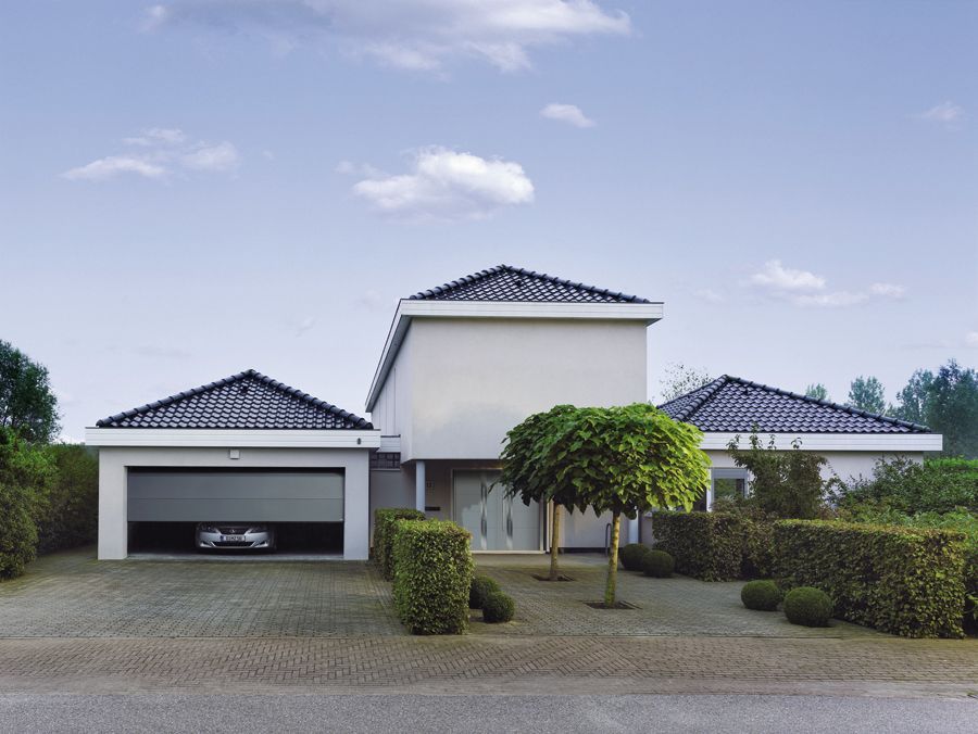 Ein großes weißes Haus mit einem schwarzen Garagentor
