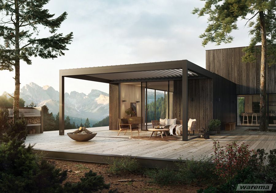 Ein Haus mit einer Pergola und einer Terrasse davor.