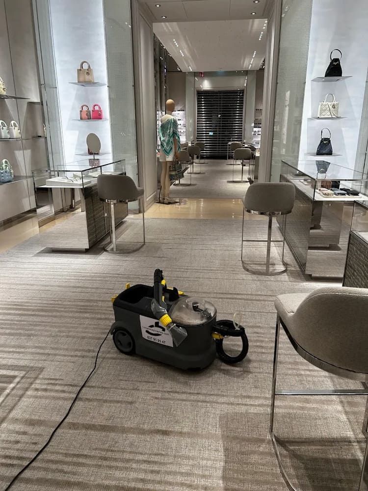 Una máquina de limpieza de alfombras en una tienda de lujo con bolsos en exhibición.