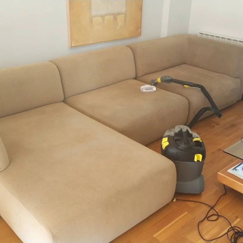 Sofá seccional color canela que se limpia con un limpiador de tapicería en una sala de estar.